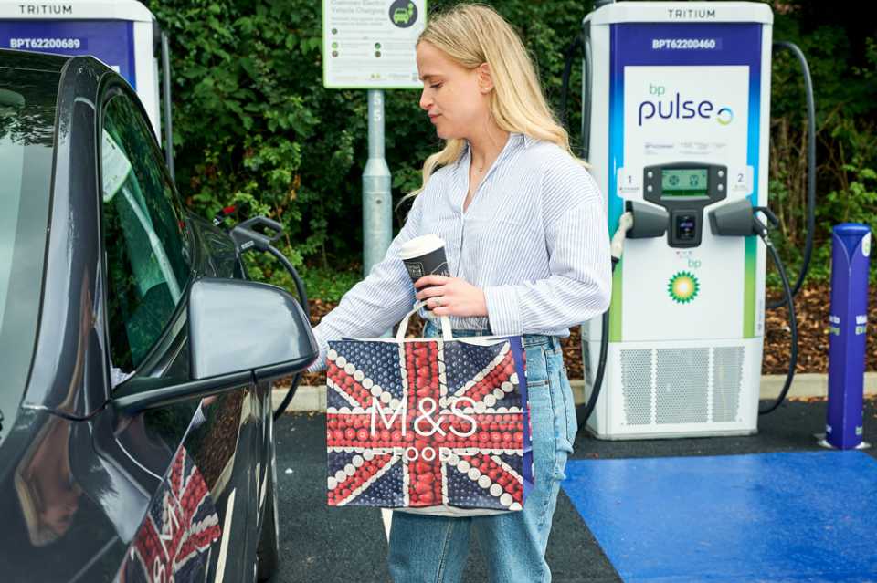 bp pulse charger at M&S store - lady holding M&S bag while charging car