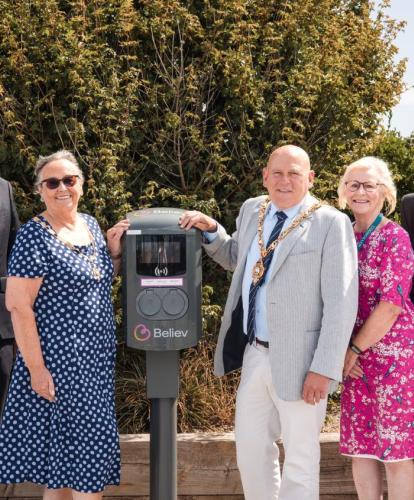 Council members stand in front of Believ charge point in Pebble Beach car park