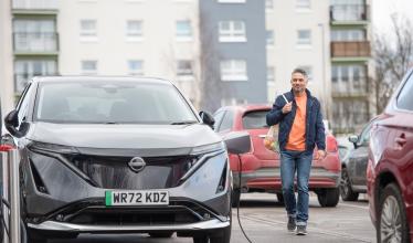 Stock photo - EV charging with man returning to car